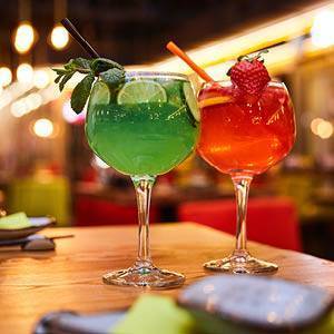 La Osteria Italiener in Dresden Altstadt Aperitivo Pizza mit Meeresfrüchten und danebenliegenden Rispen Minitomaten auf schwarzem Untergrund im La Osteria Italiener im Dresdner Zentrum