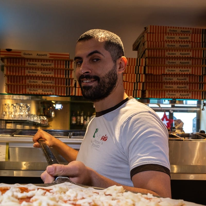 Mitarbeiter des La Osteria Pizzeria in Dresden mit Pizza auf Schieber vor dem Backen